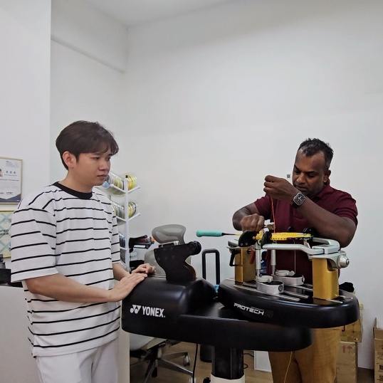 BSMY certified trainer teaching proper tension adjustment methods to Malaysian stringing students using Yonex equipment.