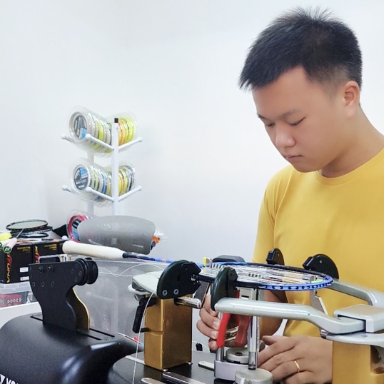 Indonesian stringer practicing advanced racquet stringing techniques during BSID certification workshop