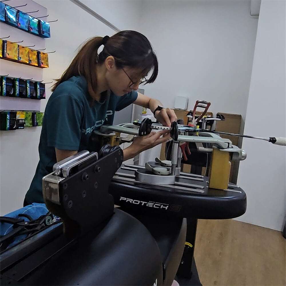 Ngan Xien Hwee tying knots for racquet stringing at BSW badminton stringing course Ngan Xien Hwee tying knots for racquet stringing at BSW badminton stringing course