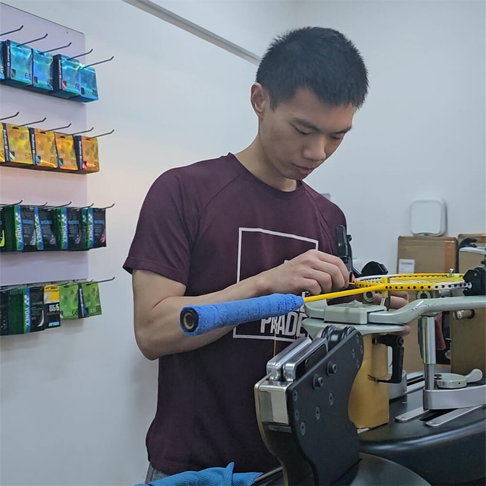 Roger Lin learning badminton stringing patterns during BSW training BSSG