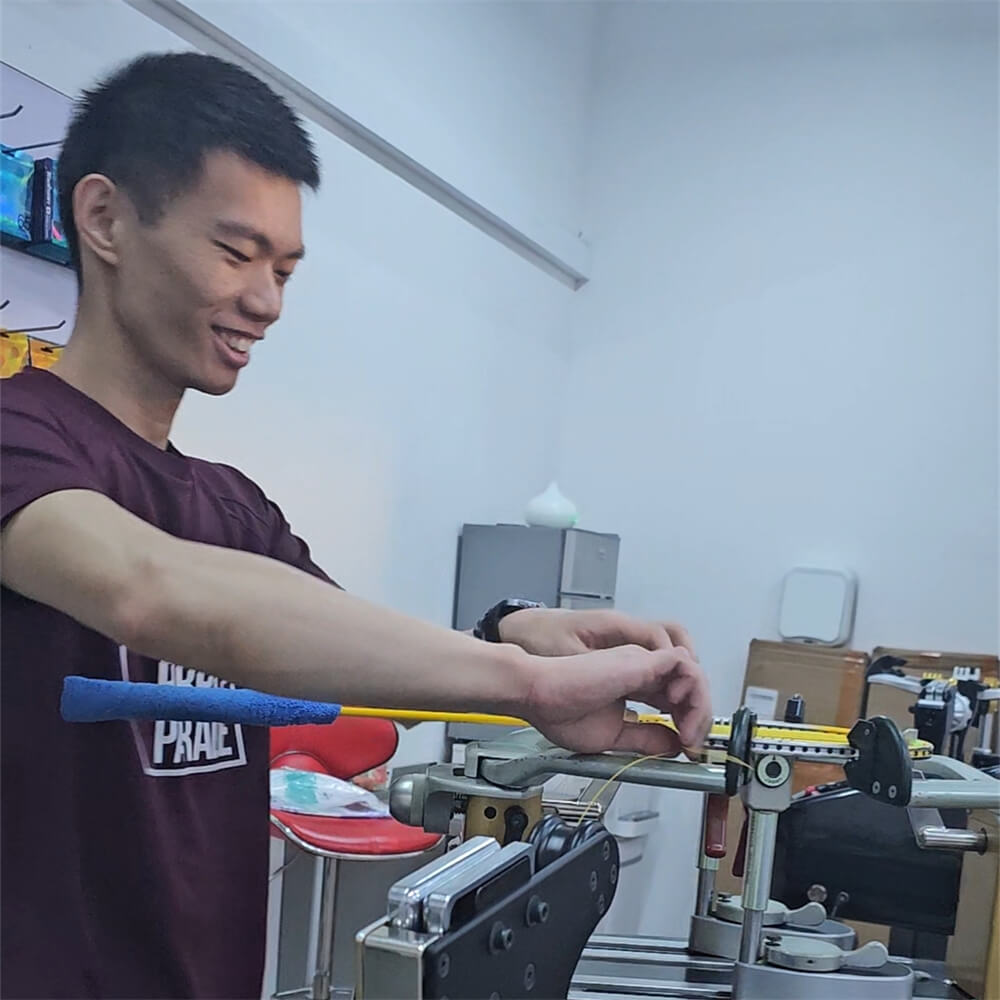 Roger Lin learning badminton stringing patterns during BSW training